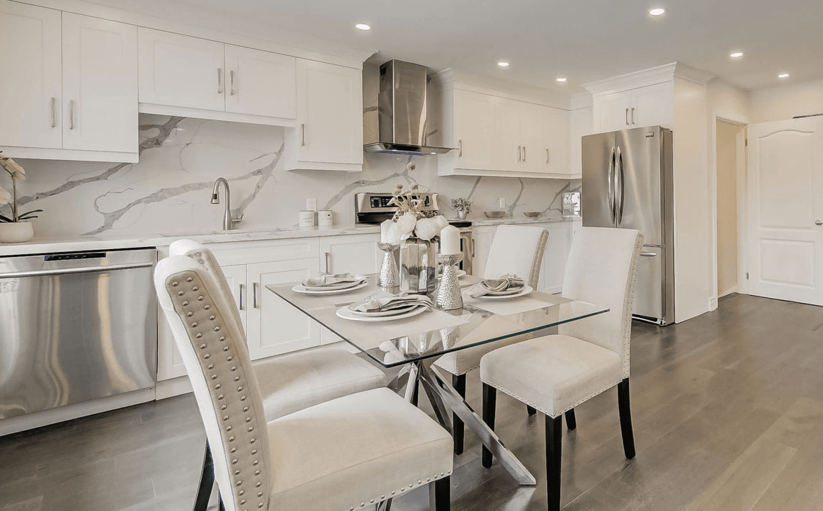 Modern kitchen with white cabinets and black countertops.